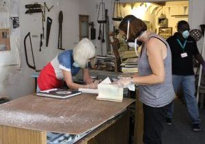 Two women reading a book in a workshop